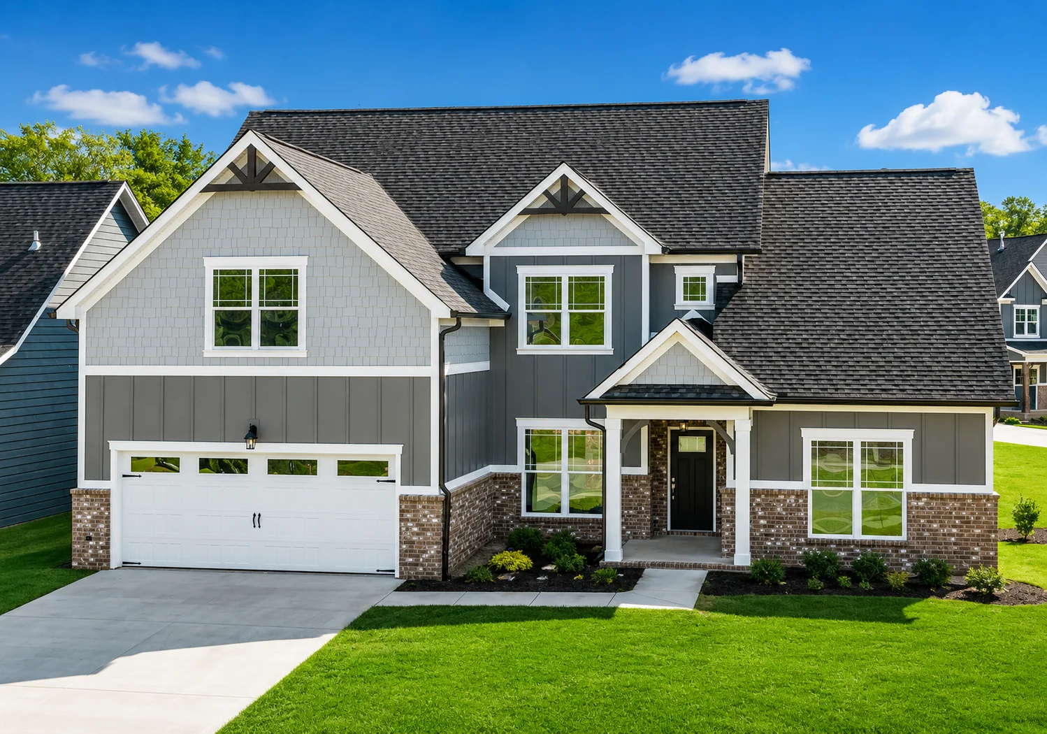 Stylish gray and brick house with a black roof and manicured lawn. Built by Pratt Home Builders in Chattanooga TN.