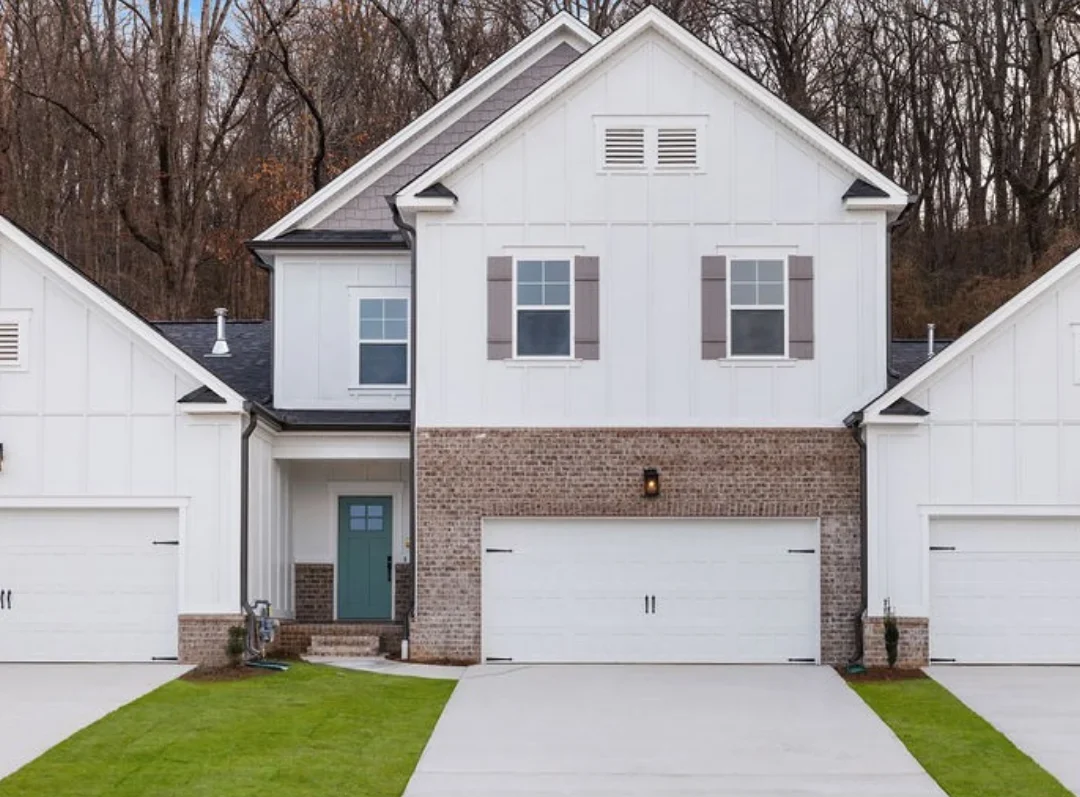 New Home Chattanooga TN. Two-story house with brick and white siding, two garage doors, and a teal front door, built by Pratt Home Builders.