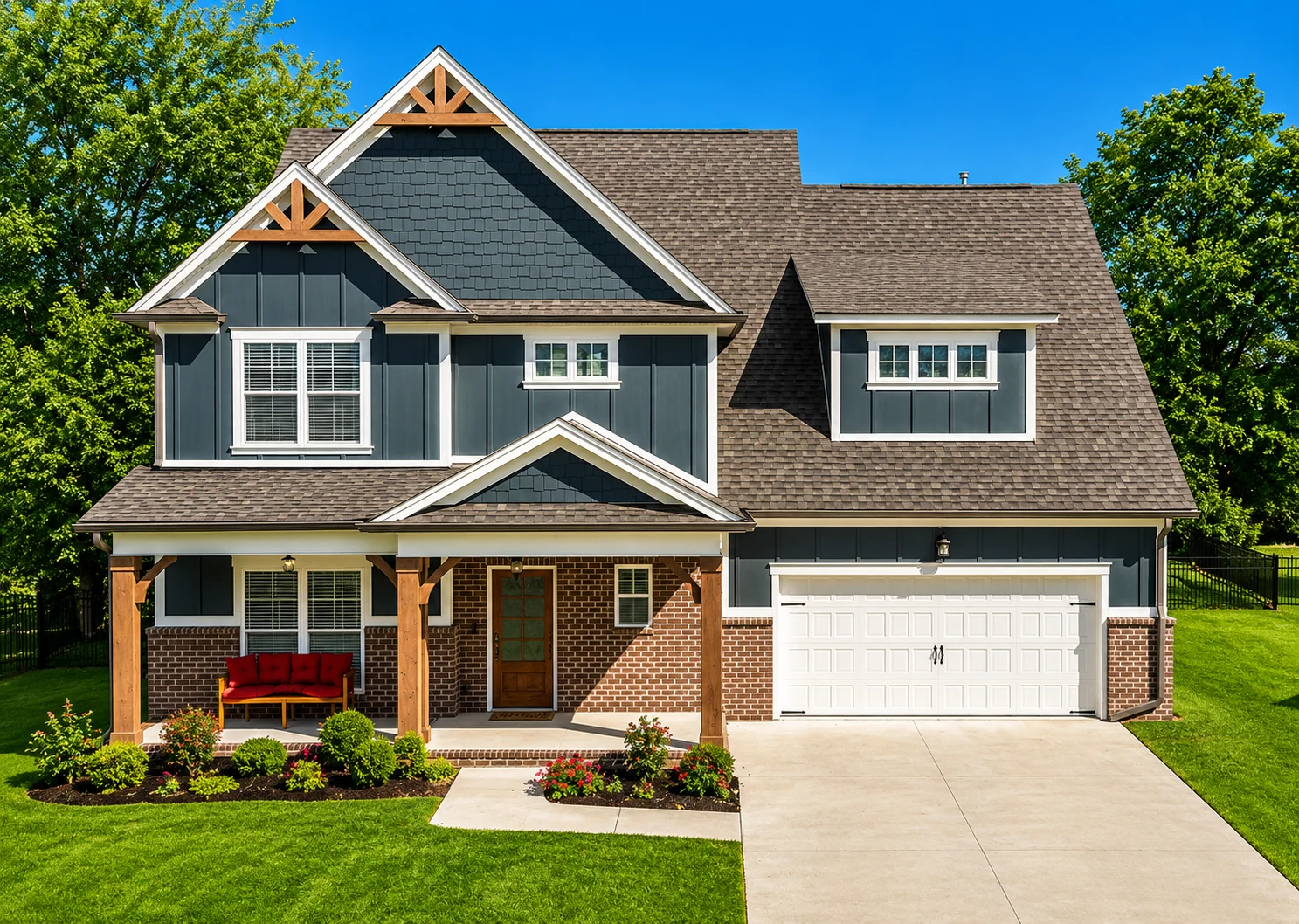 Two-story house with gray siding, brick accents, and decorative trusses, built by Pratt Home Builders in Chattanooga TN, set against a green lawn.