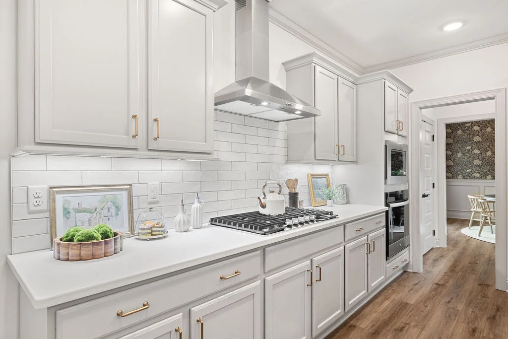 Sleek modern kitchen with white cabinetry, subway tile backsplash, and stainless appliances by Pratt Home Builders in Chattanooga TN.