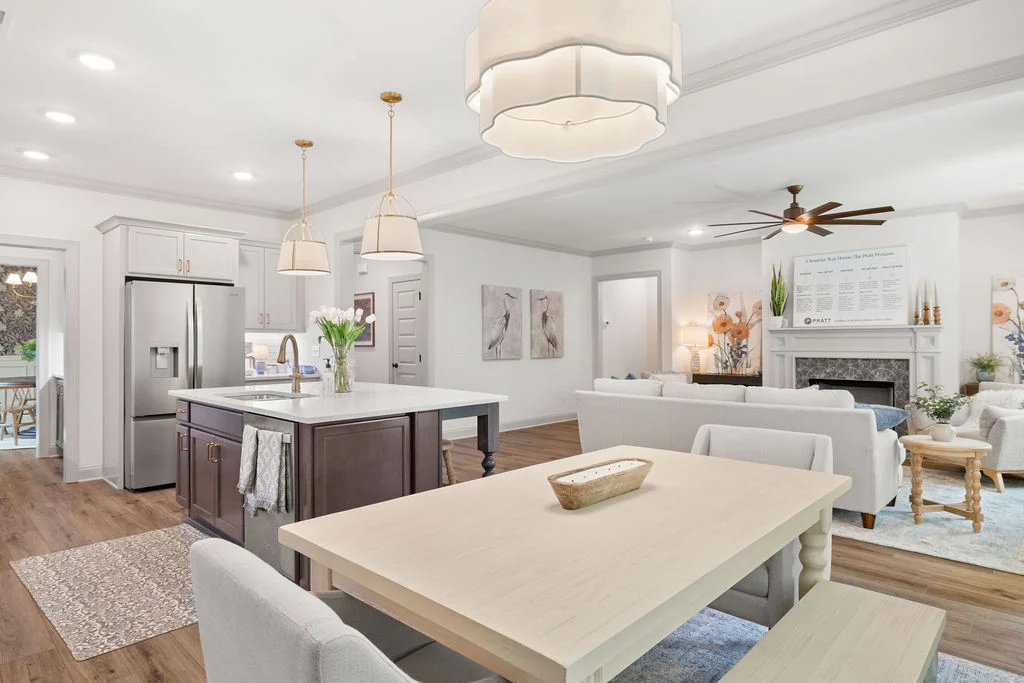 Elegant open-concept kitchen and living room with modern decor, island, and dining table, designed by Pratt Home Builders in Chattanooga TN.