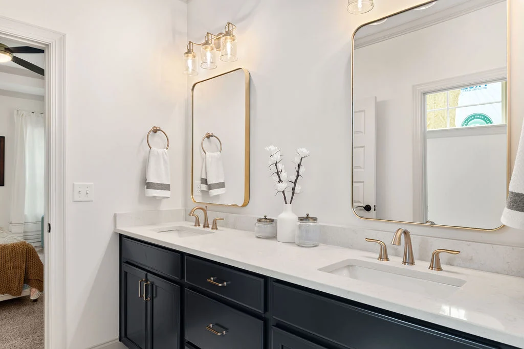 Elegant bathroom with double sink vanity, gold accents, and large mirrors by Pratt Home Builders in Chattanooga TN.