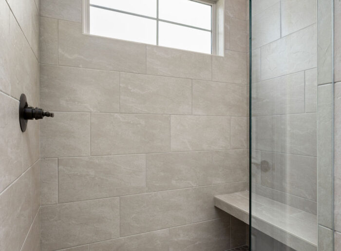 Expertly tiled oversized walk in shower in Pratt Home Builders new construction
