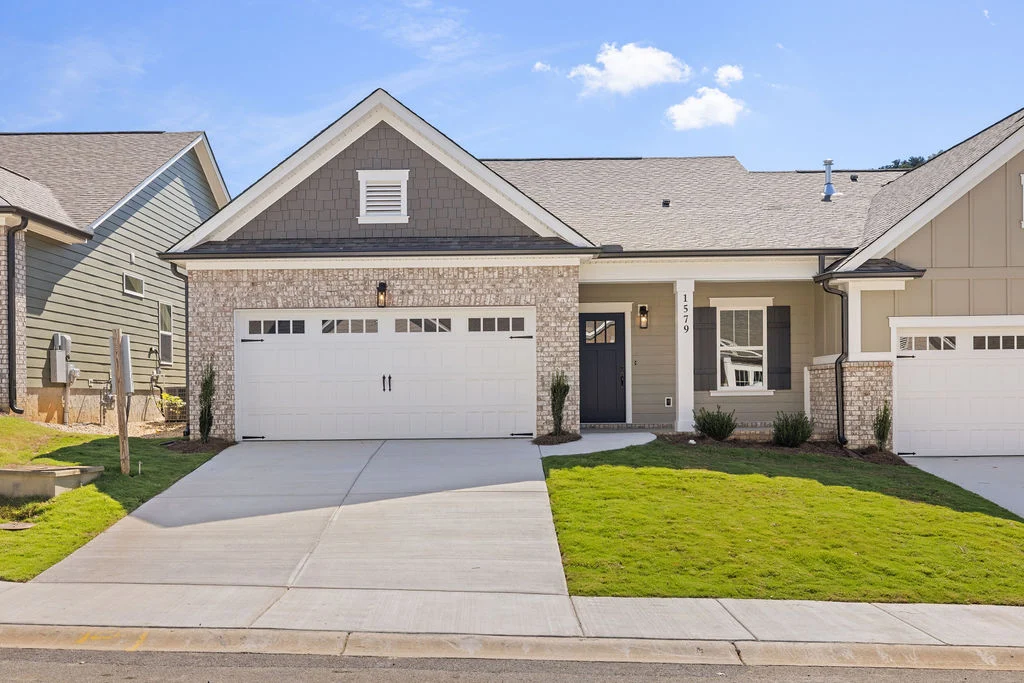 Newly constructed home with a two-car garage, brick facade, and manicured lawn by Pratt Home Builders in Chattanooga TN.