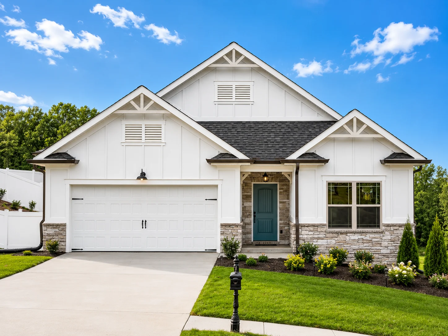 Savannah-floor-plan-front-exterior-homes-for-sale Modern white house with green lawn, stone accents, and blue door, built by Pratt Home Builders in Chattanooga TN.