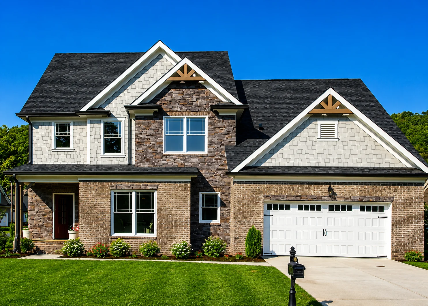 Modern two-story house with stone and brick facade, black roof, and manicured lawn, built by Pratt Home Builders in Chattanooga, TN.