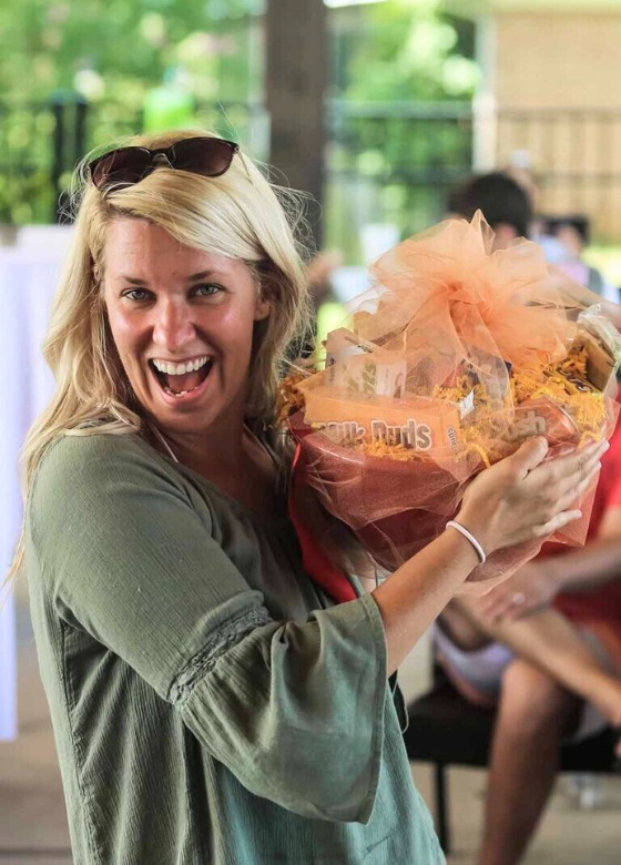 Woman holding a raffle basket from Pratt