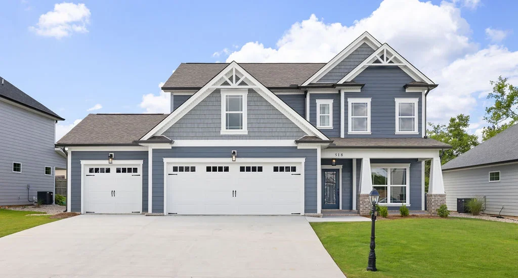 A_Peachtree-floor-plan-front-exterior Modern blue and gray two-story home with three-car garage by Pratt Home Builders in Chattanooga, TN, featuring manicured lawn and lamp post.