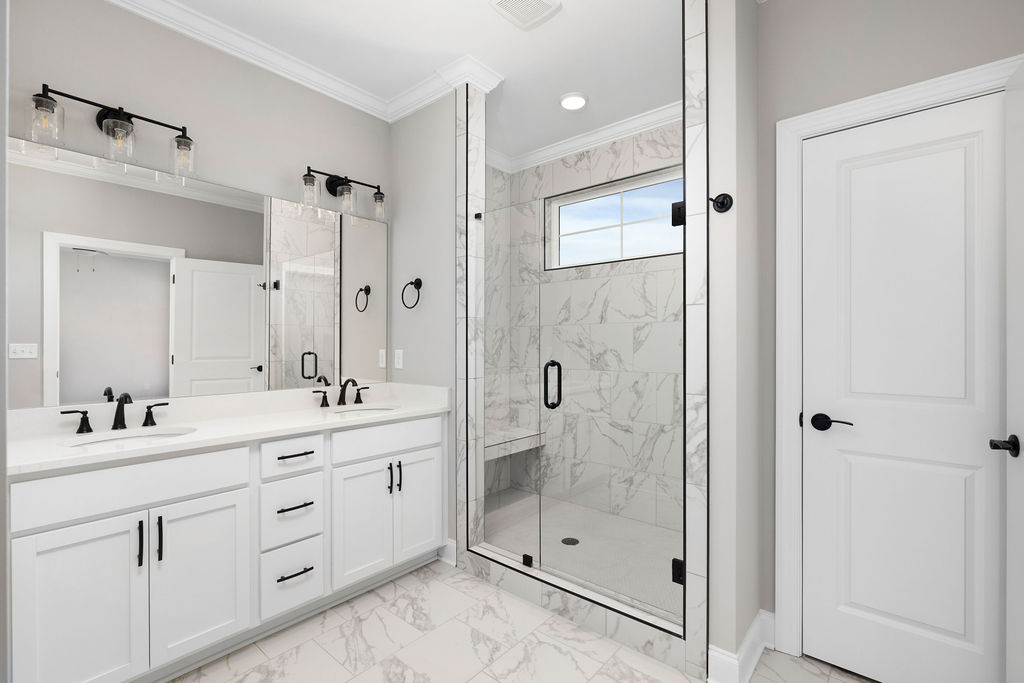 Large primary bathroom with double vanity and walk-in shower