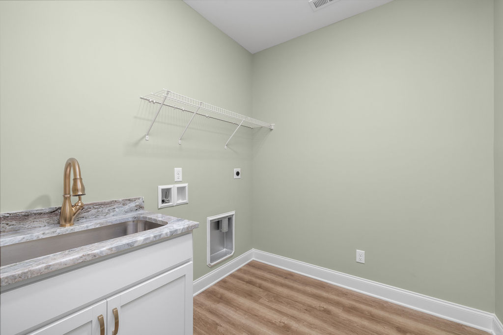 Main level laundry room with built in shelving in new Pratt construction selling now