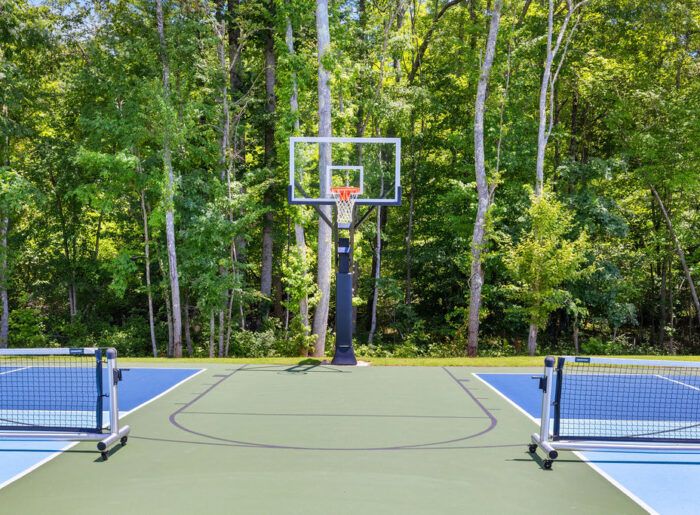 New Home Chattanooga TN. Outdoor basketball and pickleball court surrounded by trees, designed by Pratt Home Builders.