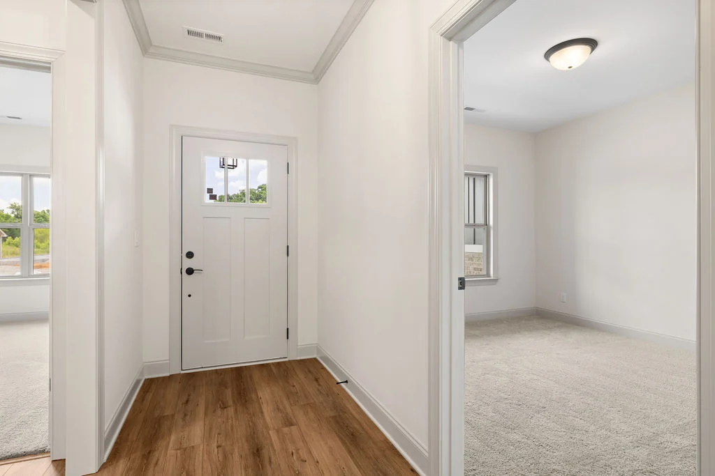 Bright hallway with wood flooring, white walls, and open rooms in a Pratt Home Builders' house, Chattanooga TN.