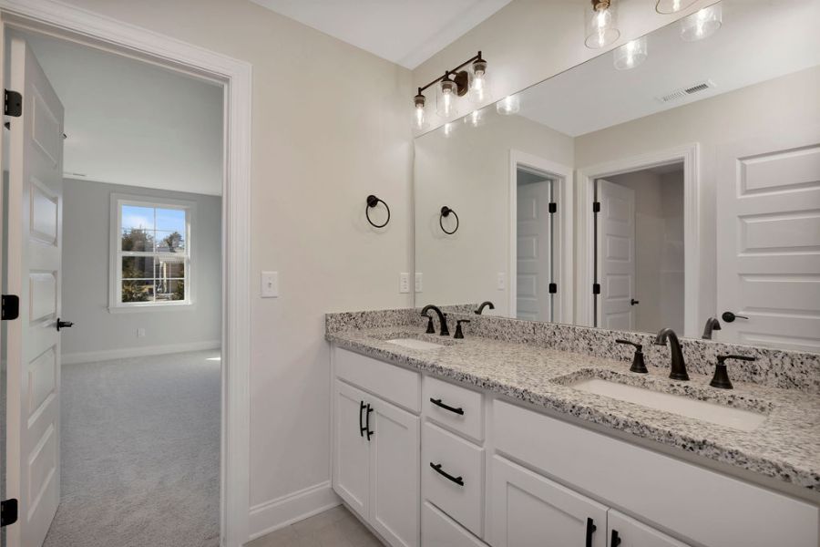 Primary bathroom with double vanity and designer finishes move-in ready