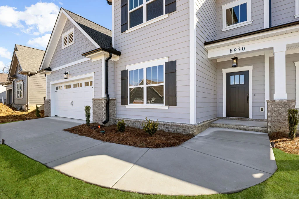 Modern gray and white two-story home with two car garage, four bedrooms now selling built by Pratt Home Builders in Chattanooga TN; features a concrete driveway and landscaped yard.
