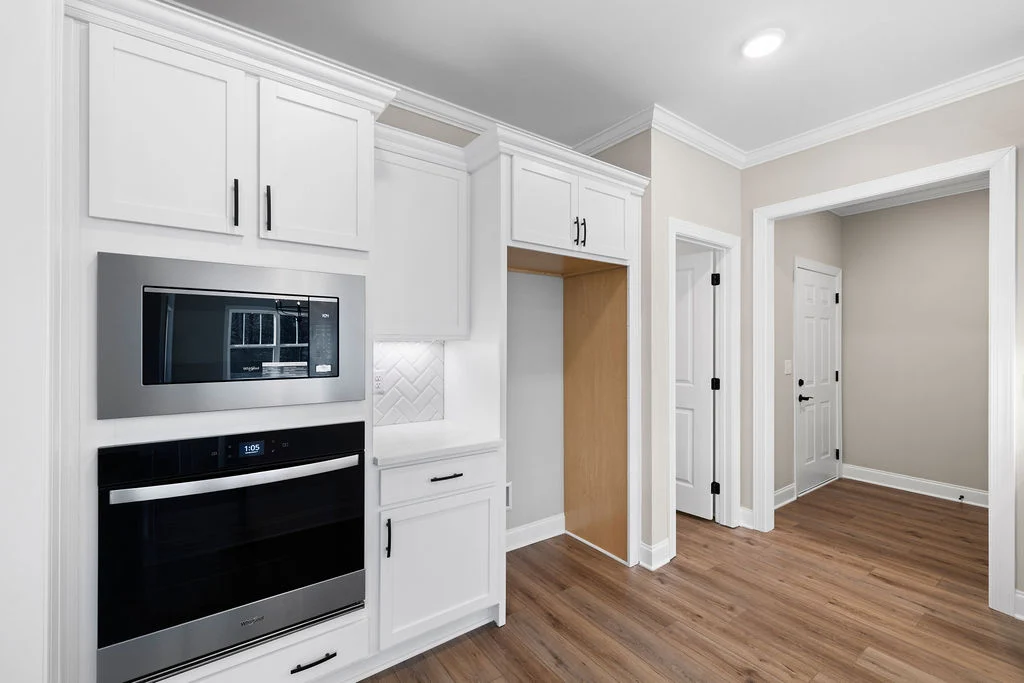 New home now selling. Gourmet kitchen with white cabinetry, chrome appliances, and wood flooring, designed by Pratt Home Builders in Chattanooga TN.