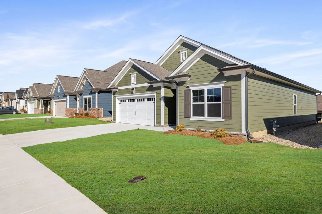 3 bedrooms. Single-story green home with a two-car garage and well-maintained lawn, built by Pratt Home Builders in Cleveland TN.