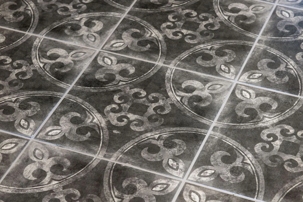 Ornate black and white tile with circular patterns and floral motifs, featured by Pratt Home Builders in Chattanooga TN.