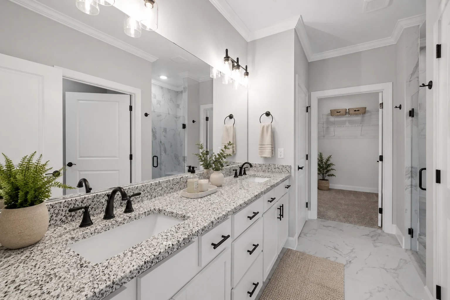 Modern bathroom with double sink, granite countertop, and elegant lighting by Pratt Home Builders in Chattanooga TN.