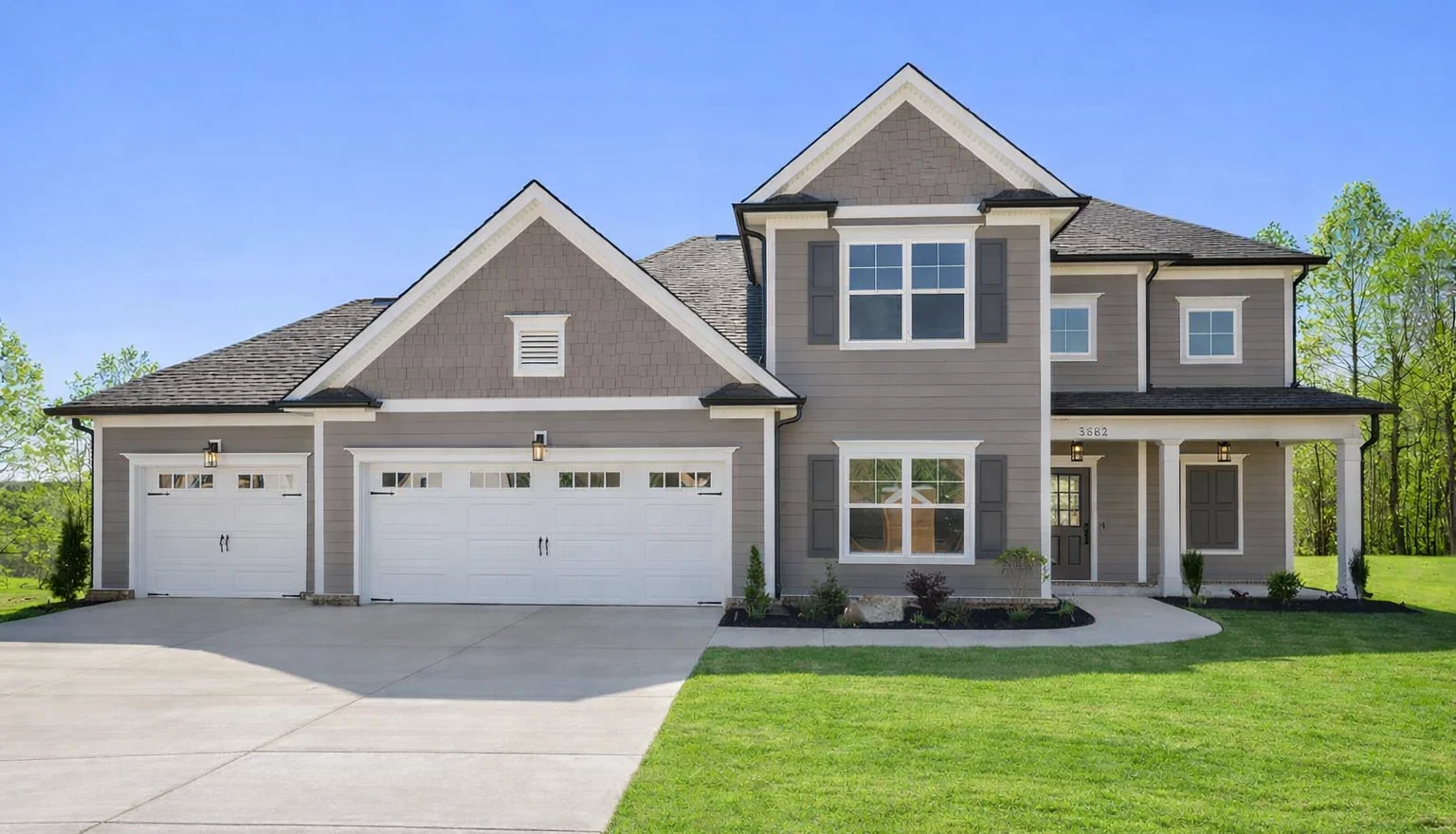 New Home Chattanooga TN. Two-story house with gray siding, three-car garage, and manicured lawn by Pratt Home Builders.