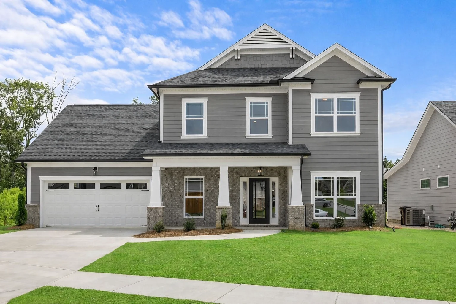 New modern gray two-story home with garage, lush lawn, and white trim, built by Pratt Home Builders in Chattanooga TN.