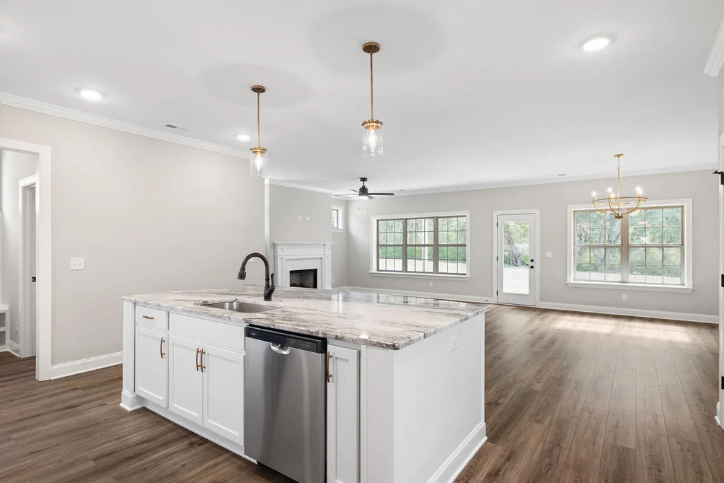 Spacious open-concept living area by Pratt Home Builders in Chattanooga TN, featuring a modern kitchen island, fireplace, and large windows.