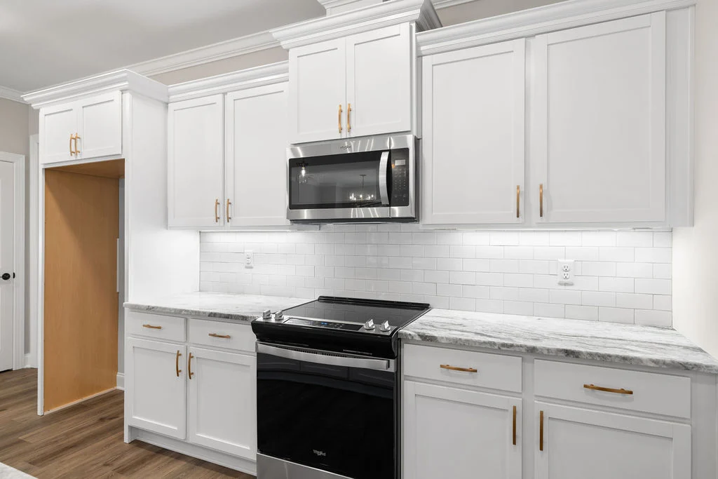 Modern kitchen with white cabinets, granite countertop, stainless steel appliances, and subway tile backsplash by Pratt Home Builders in Chattanooga TN