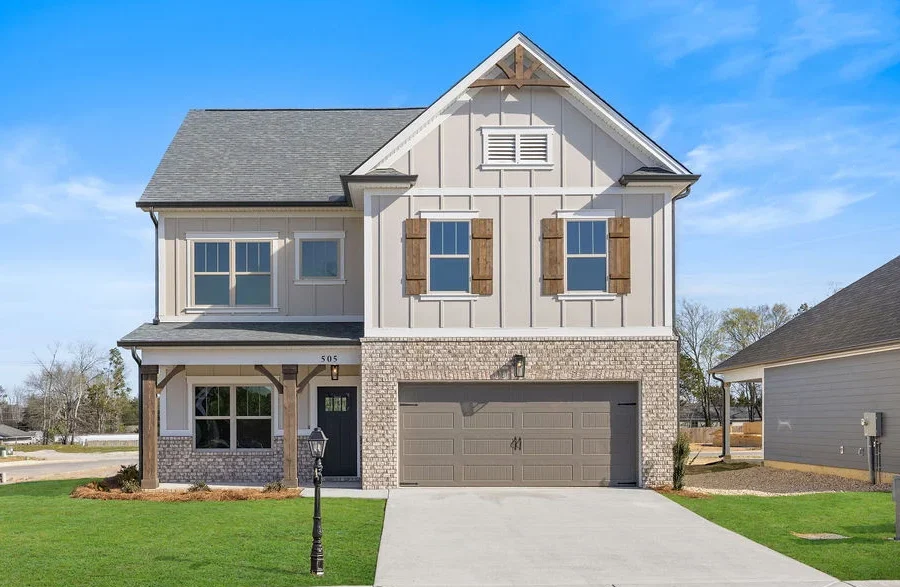 Quail-Run-floor-plan-exterior-front New home Chattanooga TN. Two-story house with brick and siding exterior, double garage, and manicured lawn by Pratt Home Builders.
