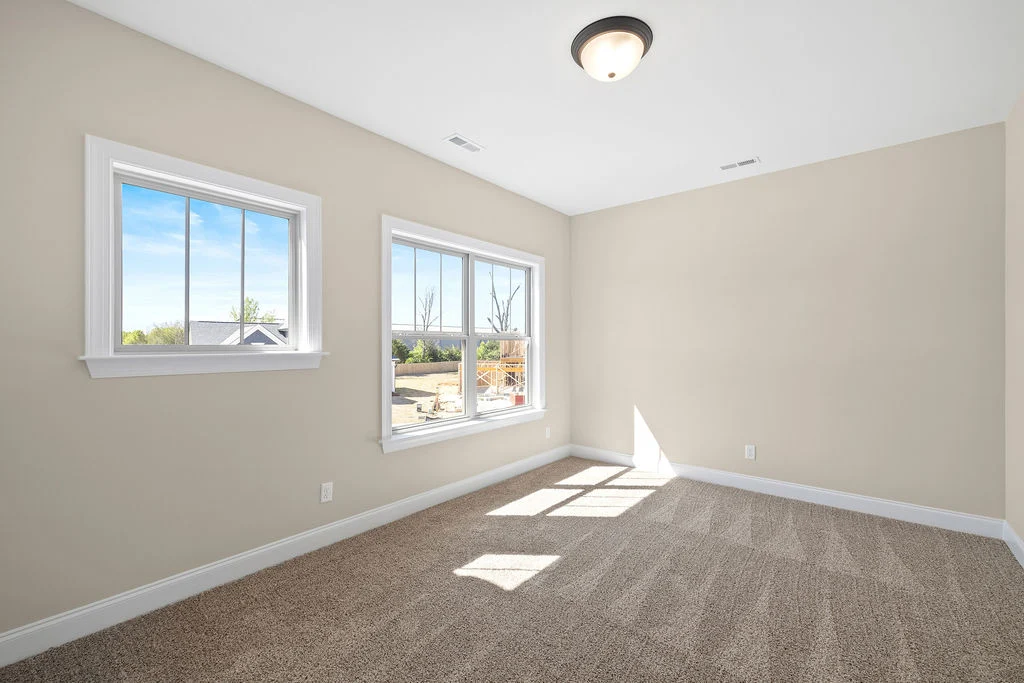 New Home Chattanooga TN. Bright room with beige walls, carpet flooring, and two windows; built by Pratt Home Builders.