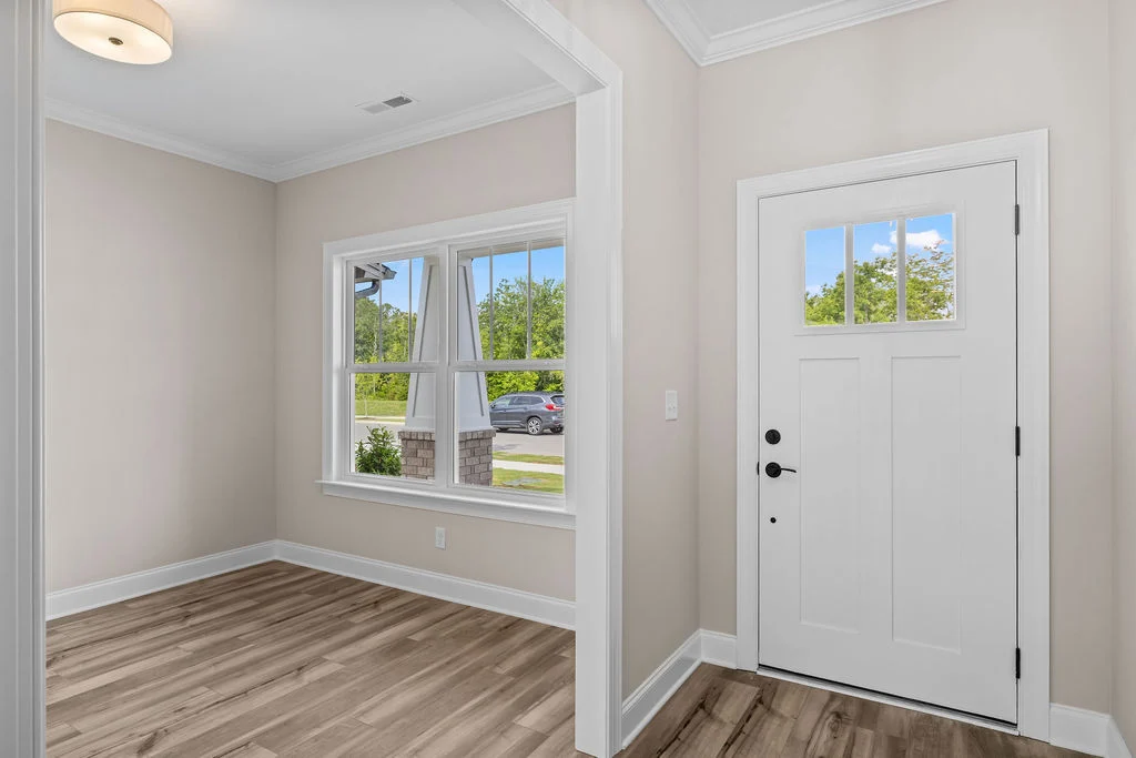 Entryway with a white door and large window, featuring hardwood floors, built by Pratt Home Builders in Chattanooga TN.