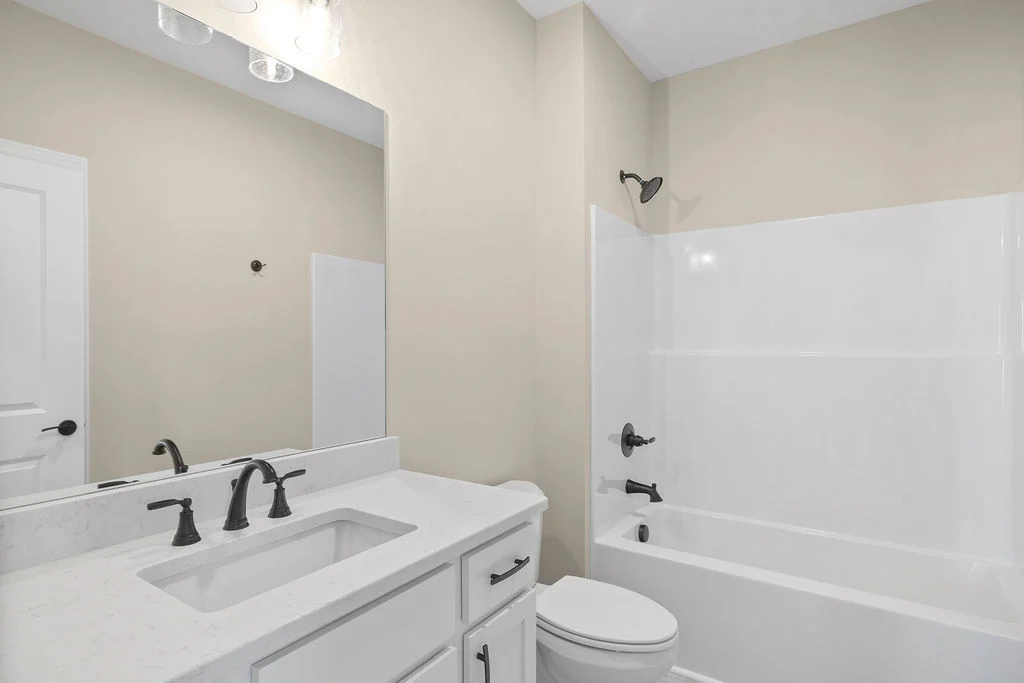 New Home Chattanooga TN. Modern bathroom with white vanity, black fixtures, and a bathtub by Pratt Home Builders.