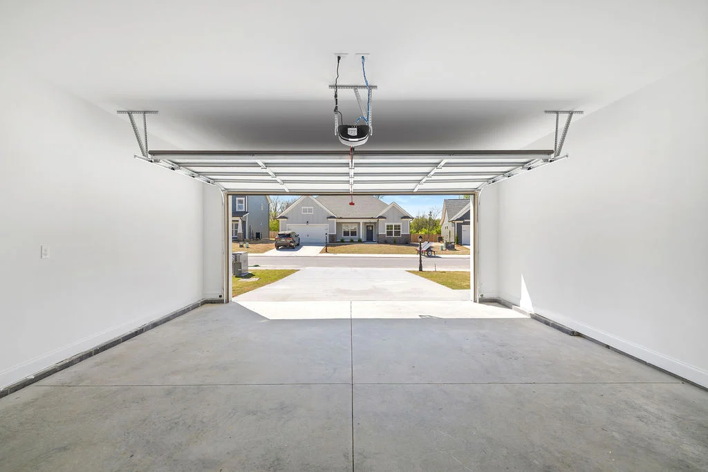 New Home Chattanooga TN. Spacious garage interior with open door view of suburban neighborhood by Pratt Home Builders.
