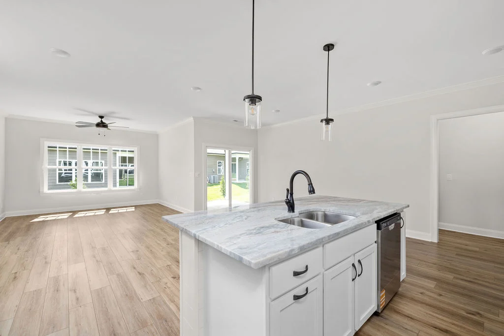 Spacious open-concept kitchen and living area with marble island, hardwood floors, and natural light by Pratt Home Builders in Chattanooga TN.