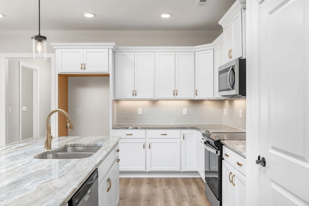 New home Chattanooga TN. Modern kitchen with white cabinetry, stainless steel appliances, and granite countertops, designed by Pratt Home Builders.