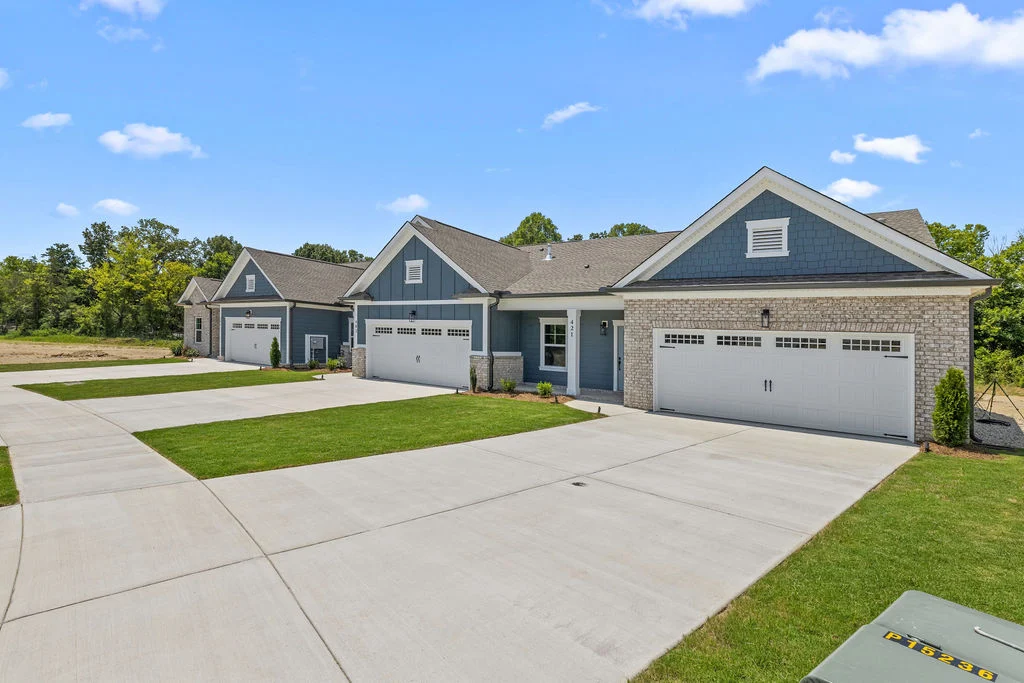Modern townhome with brick and blue siding, featuring spacious driveways, built by Pratt Home Builders in Chattanooga TN.