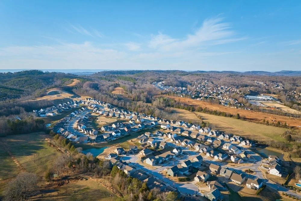 Chattanooga’s Trending in 2026 Now’s the Time to Invest Aerial view of a suburban neighborhood by Pratt Home Builders in Chattanooga, TN, nestled among scenic hills and greenery under a clear sky.