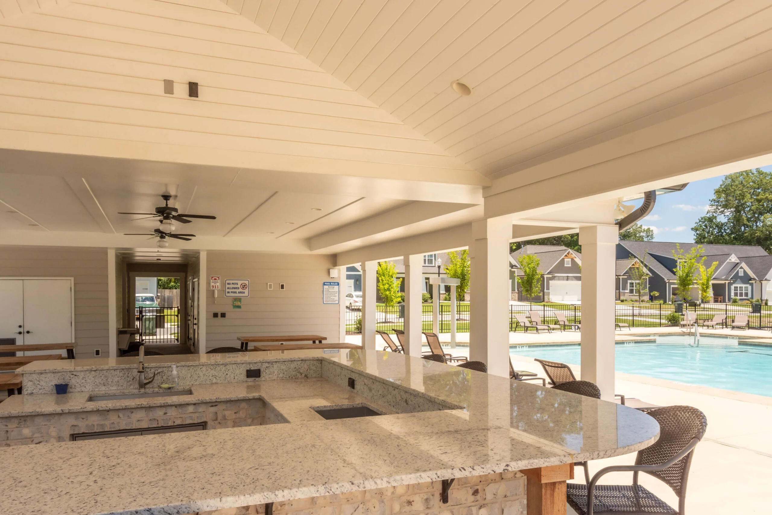 Covered patio with granite bar seating beside a pool at a Pratt Home Builders community in Chattanooga, TN.