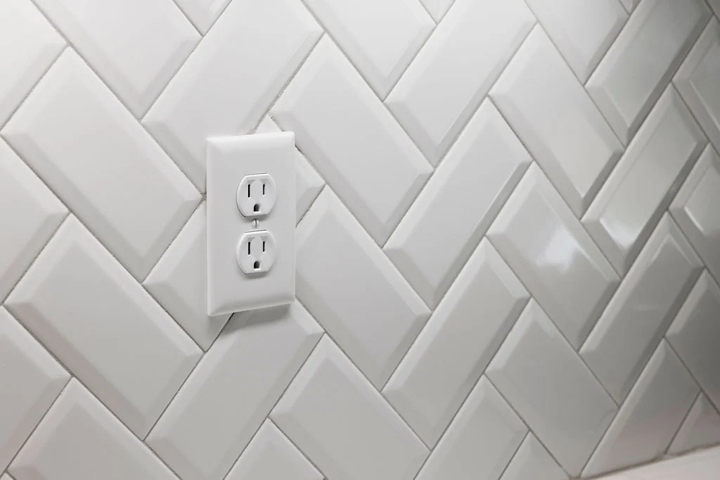 Designer herringbone-patterned white tile backsplash by Pratt Home Builders in Chattanooga TN.