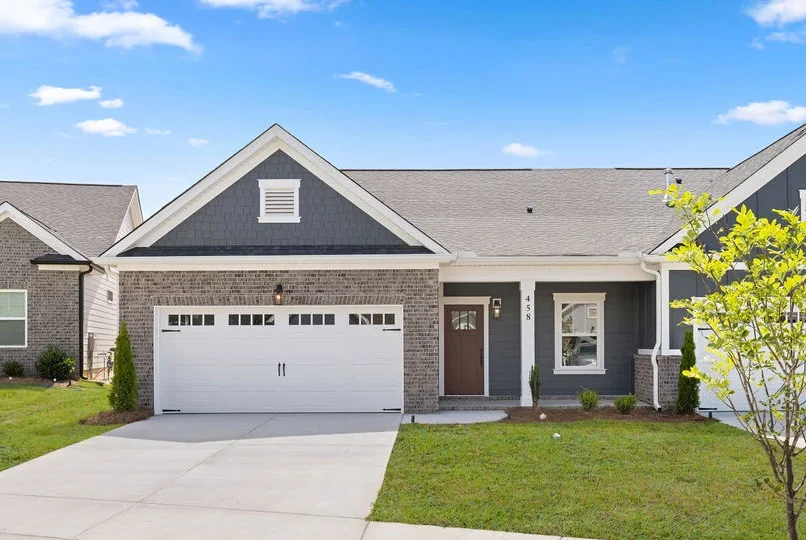 Single-story home with brick facade, double garage, and small tree in yard, built by Pratt Home Builders in Chattanooga TN.