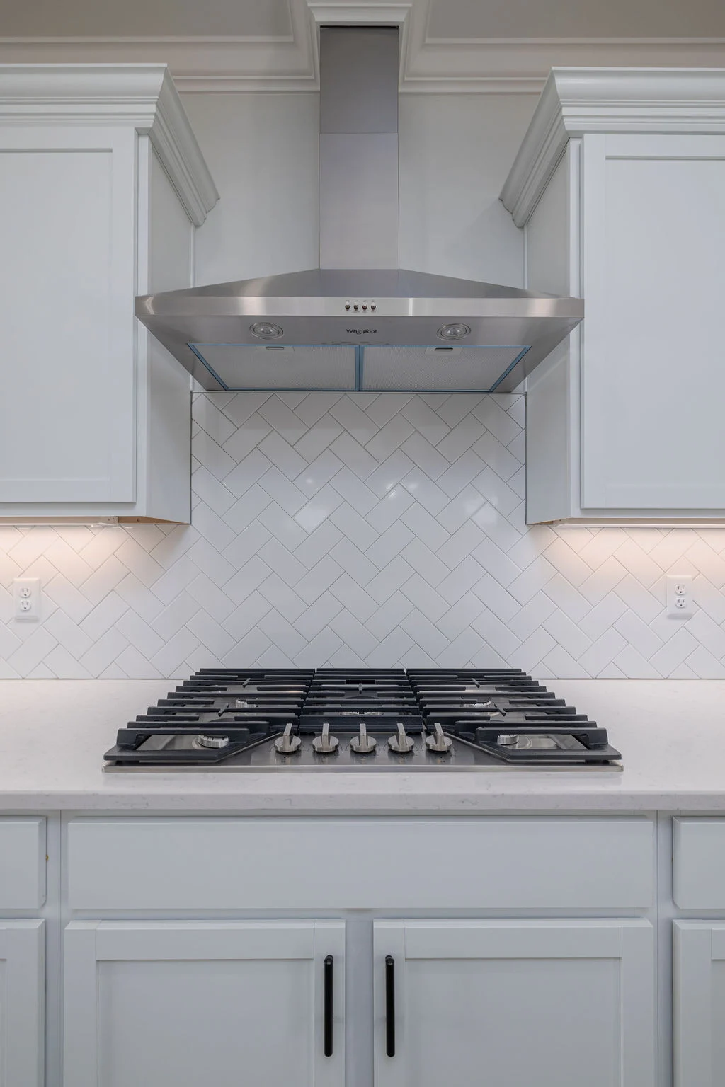 New Home Chattanooga TN. Modern kitchen by Pratt Home Builders featuring stainless steel range hood, gas stove, and white herringbone tile backsplash.
