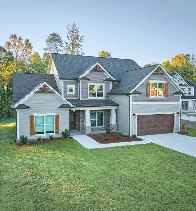 Pratt Home Spacious suburban home with stone and wood accents, large garage, surrounded by greenery. Built by Pratt Home Builders in Chattanooga TN.