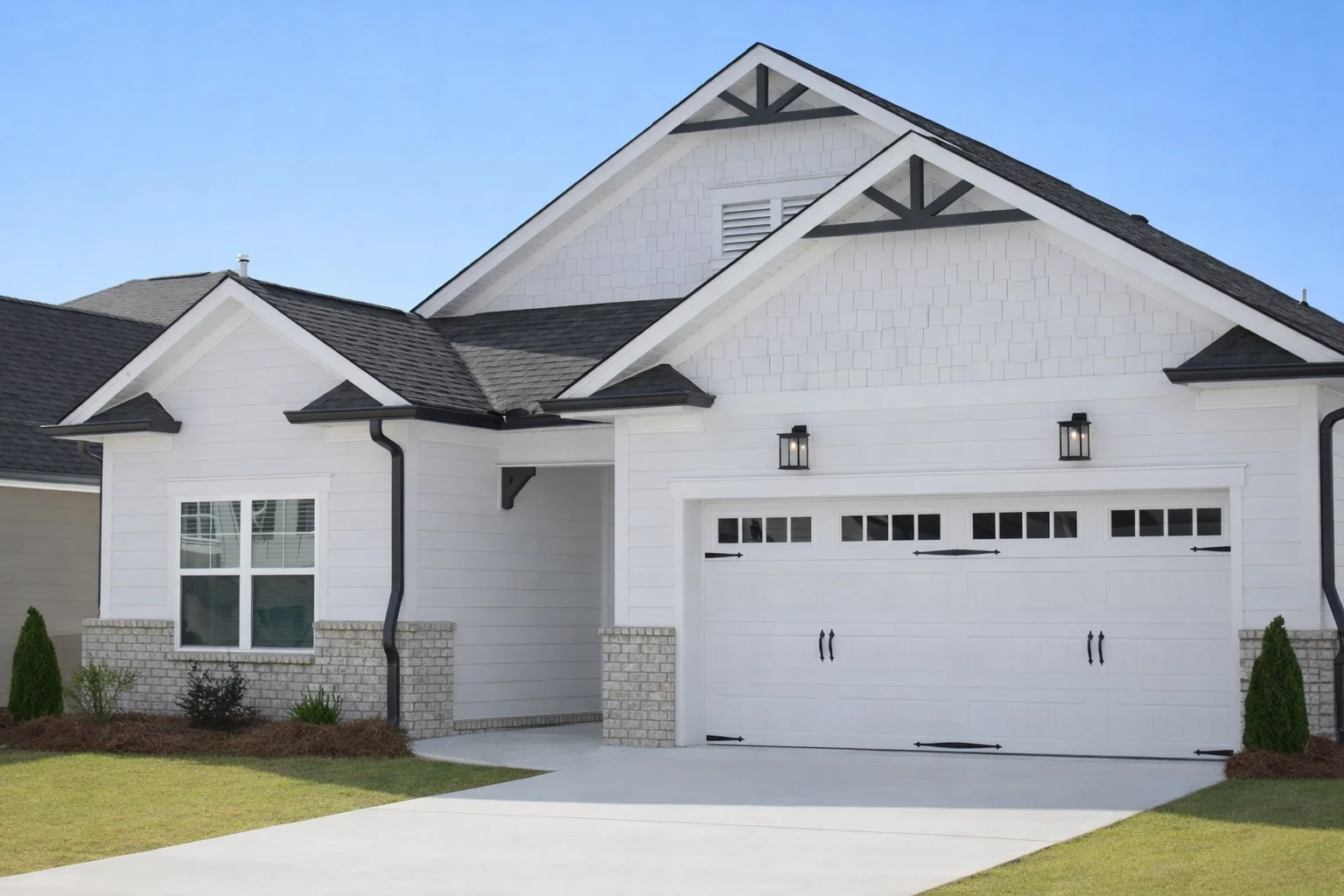 Modern white home with brick accents, double garage, and gable roof, built by Pratt Home Builders in Chattanooga TN.