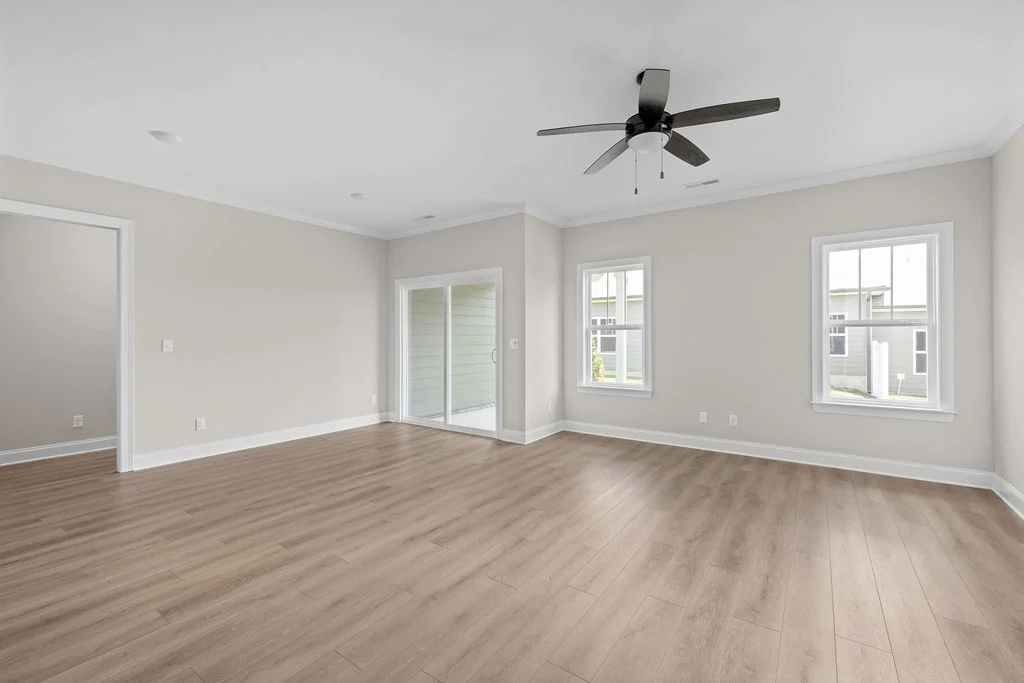 New Home Chattanooga TN. Spacious, modern living room with wood flooring and large windows by Pratt Home Builders.