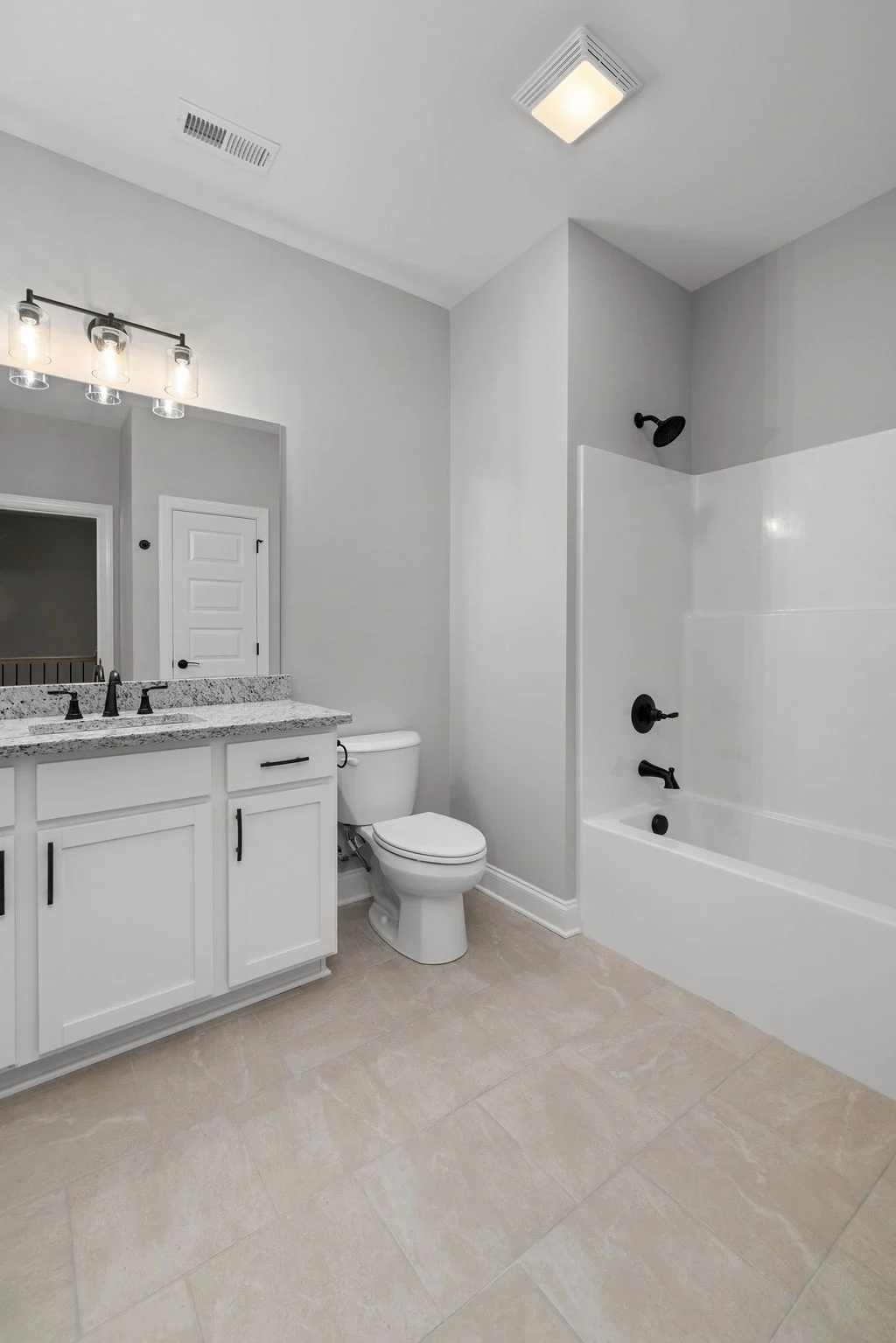 New Home Chattanooga TN. Modern bathroom with granite countertop, white cabinets, bathtub, and sleek fixtures by Pratt Home Builders.