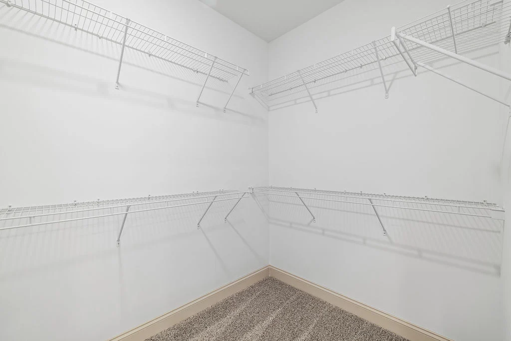 New Home Chattanooga TN. Spacious walk-in closet with white wire shelving, beige carpet floor, designed by Pratt Home Builders.