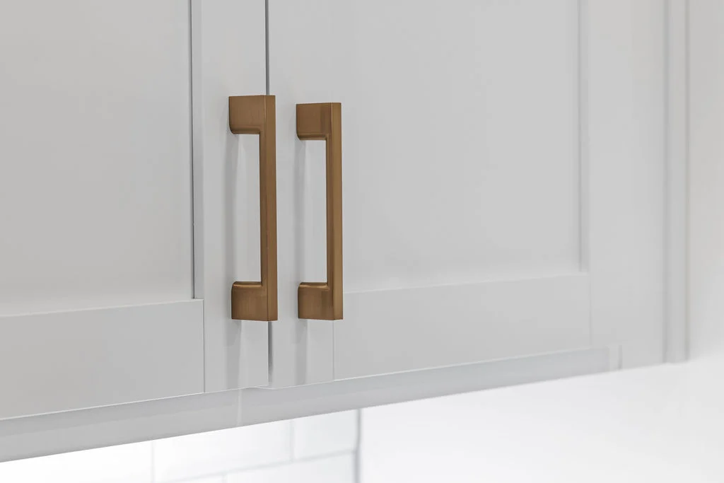 White cabinet doors with sleek gold handles, showcasing elegant design by Pratt Home Builders in Chattanooga TN.