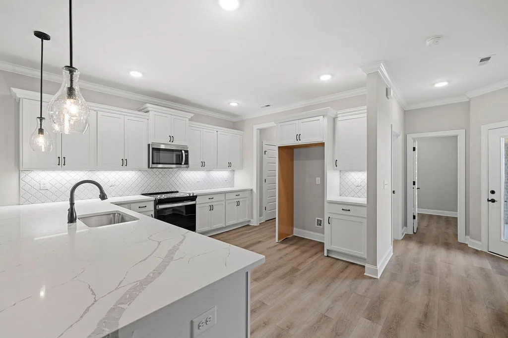 New Home Chattanooga TN. Modern kitchen by Pratt Home Builders; white cabinets, marble countertops, pendant lights, stainless steel appliances.