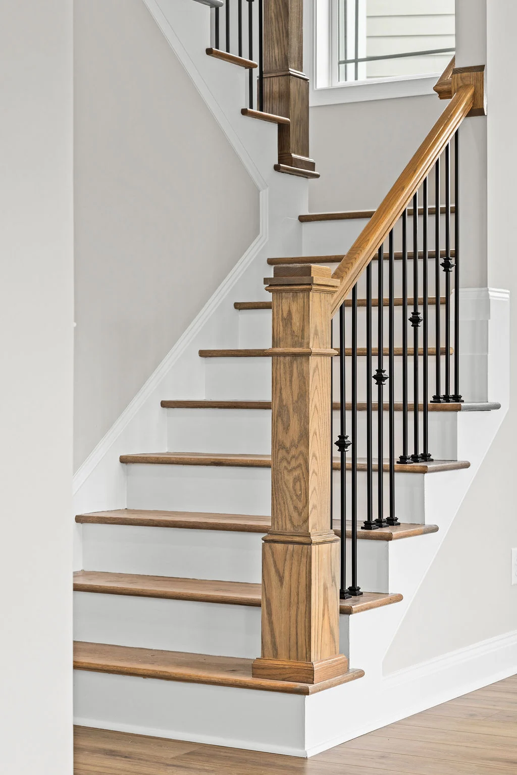 New Home Chattanooga TN. Elegant wooden staircase with black iron balusters; craftsmanship by Pratt Home Builders.