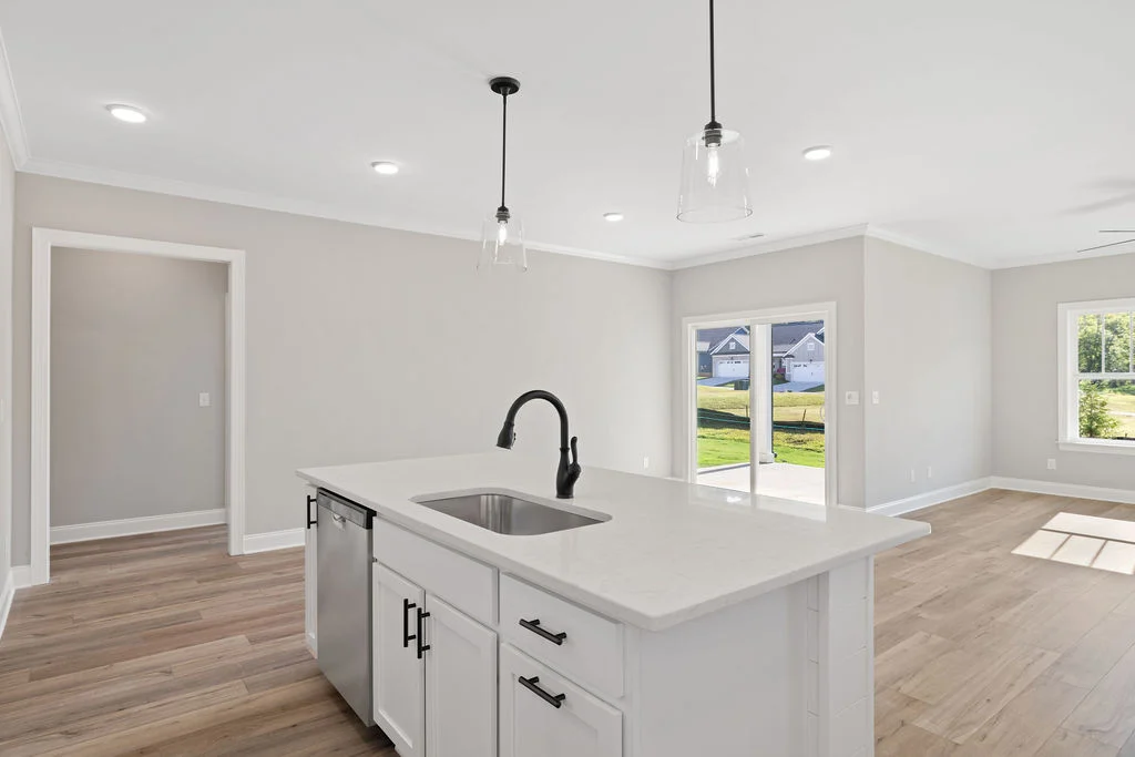Spacious modern kitchen with island, bright lighting, and sliding doors leading to a sunny backyard. Designed by Pratt Home Builders in Chattanooga TN