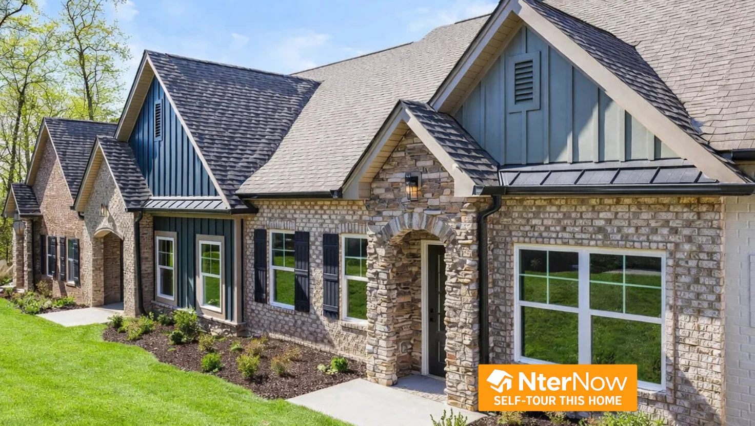 Stone and wood exterior of a modern house with lush lawn, built by Pratt Home Builders in Chattanooga TN. NterNow self-tour sign visible.
