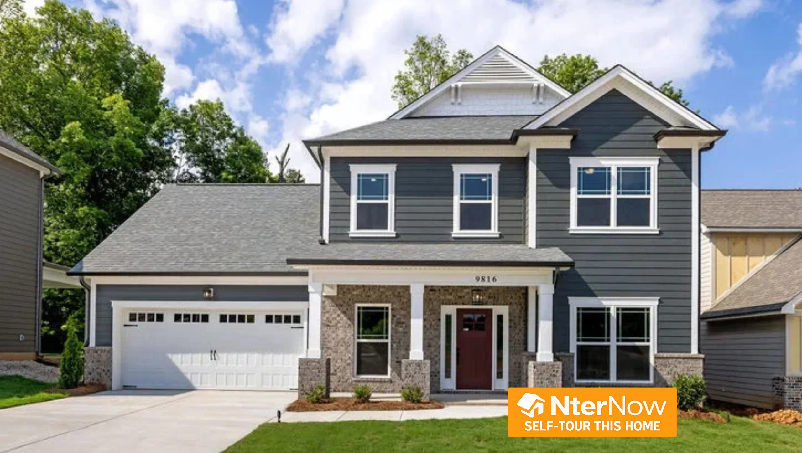 Two-story modern house with gray siding, brick accents, and a red door, built by Pratt Home Builders in Chattanooga, TN. NterNow self-tour sign visibl